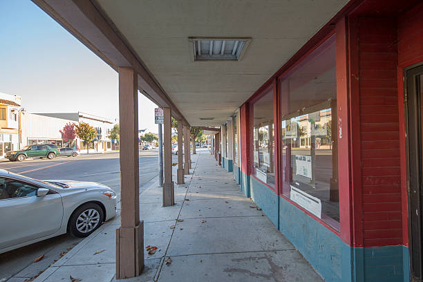 King City, California - July 8, 2016: King city downtown. Business area, stores and restraurant on the sides. Cars are parked on the street. Incidental people on the background.