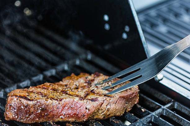Close-up shot of a sirloin steak cooking on the bbq.