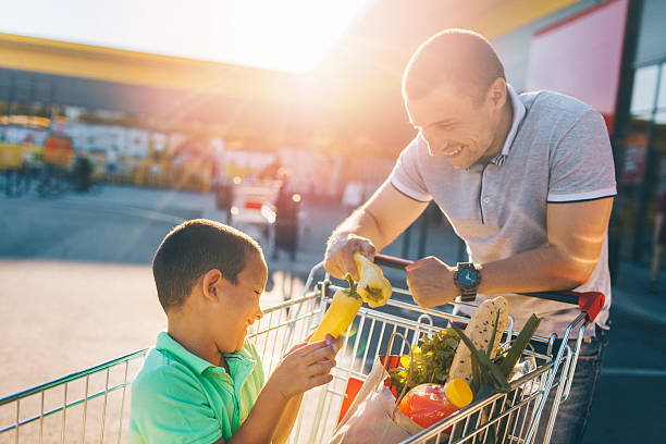 Father and son having fun after grocery shopping