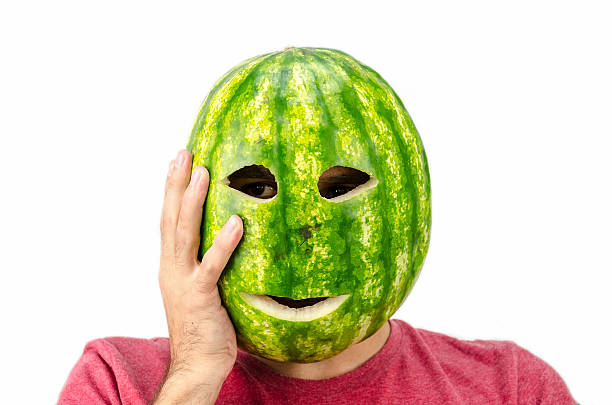 uomo che tiene maschera di frutta o anguria sul viso - liar dishonesty costume men foto e immagini stock