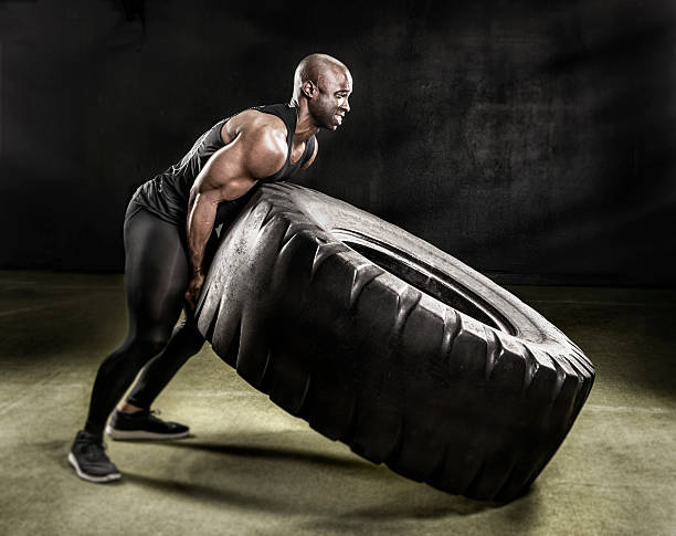 Heavy duty tire lift. Athlete workout with Heavy Tire lift. weight training photos stock pictures, royalty-free photos & images