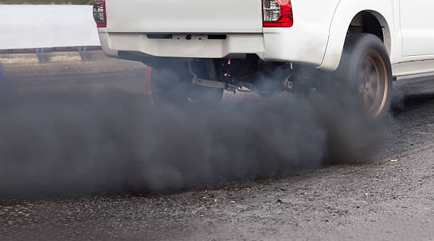 Air pollution from vehicle exhaust pipe on road