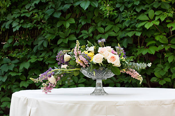 A table at a wedding lined with floral centerpieces and place settings.