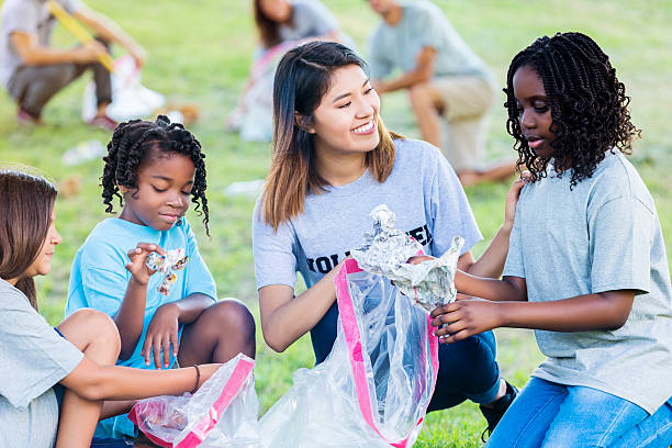 istock Woman helps kids clean up park 546452206