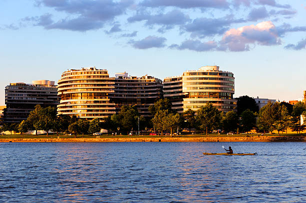 Watergate hotel and apartments at golden hour across the Potomac. Washington, DC, USA - June 07 2016: Watergate hotel and apartments at golden hour with a Kayak in the Potomac. hotel watergate stock pictures, royalty-free photos & images