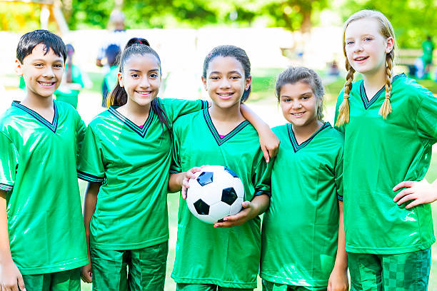 zróżnicowana drużyna piłkarska z piłką nożną - football child american football team zdjęcia i obrazy z banku zdjęć