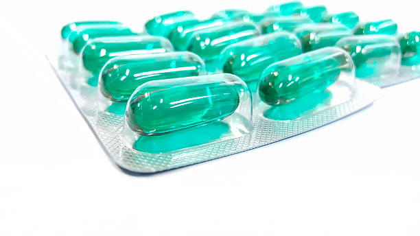 istock Green capsule blisters on white background 546453940