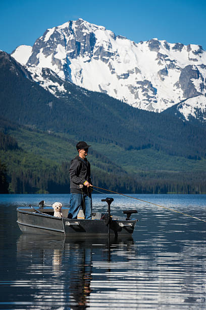 Fly fishing with man's best friend Fly fishing from a boat on a stunning mountain lake with a dog pemberton bc stock pictures, royalty-free photos & images