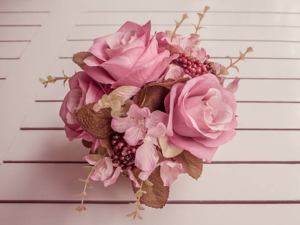 istock Vintage artificial bouquet on wooden table 546455864