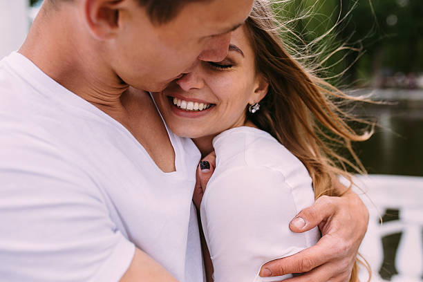 guy hugging his girlfriend stock photo