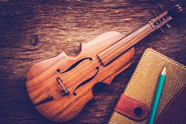 istock Violin and notebook with pencil on grunge dark wood background, 546457940