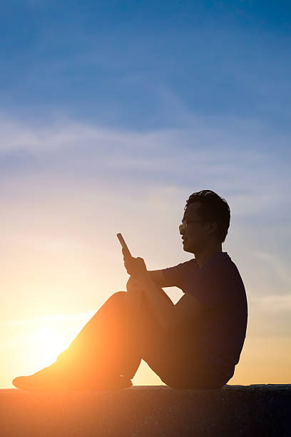 istock man looking phone at sunrise 546458144