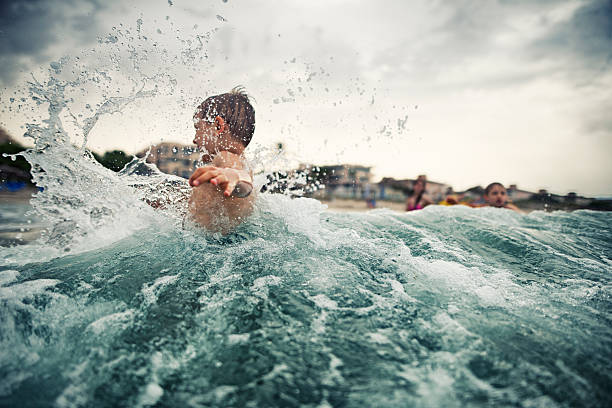 Little boy playing in cold sea waves