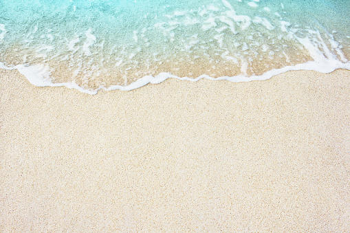Suave ola azul del océano en la playa de arena photo