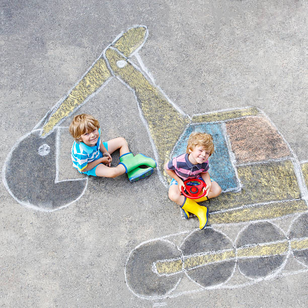 istock Two little kid boys with excavator chalk picture 546462740