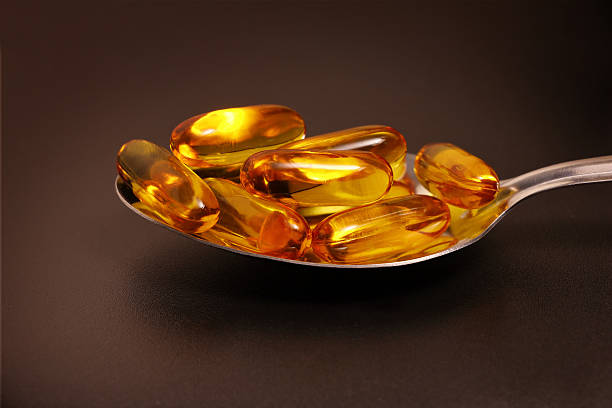 istock Fish oil in spoon with black background 546463790