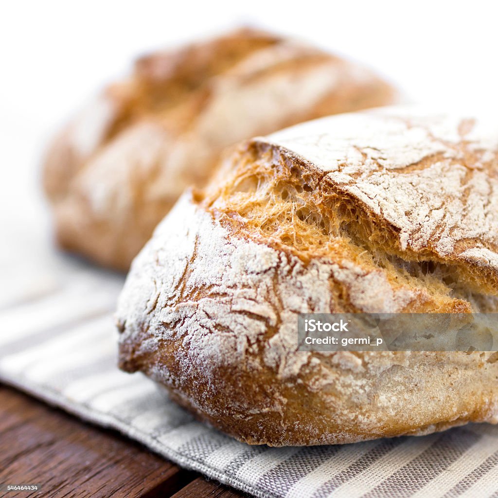 Rustic loaf of bread Freshly baked traditional bread on wooden table. Defocused blurry background. Bread Stock Photo