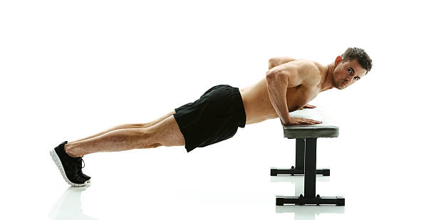 istock Shirtless muscular man exercising on bench 546465968