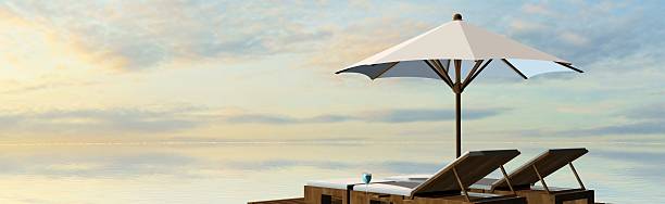 istock Deck Chairs and umbrella in sunset on the beach 546466312