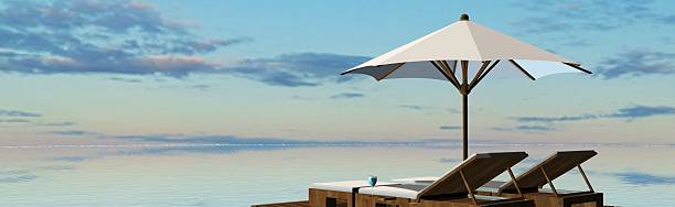 istock Deck Chairs and umbrella in sunset on the beach 546466408