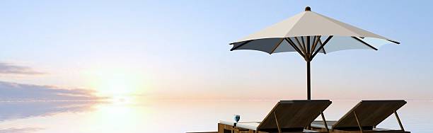 istock Deck Chairs and umbrella in sunset on the beach 546466692