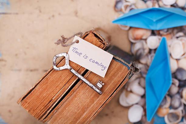 Time is coming sign on vintage key and old book stock photo