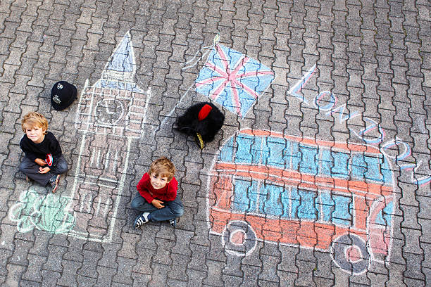 istock Two little kids with London picture drawing with chalks 546761398
