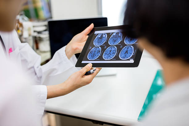 Doctor and patient using digital tablet in hospital Doctor and patient using digital tablet brain tumour stock pictures, royalty-free photos & images