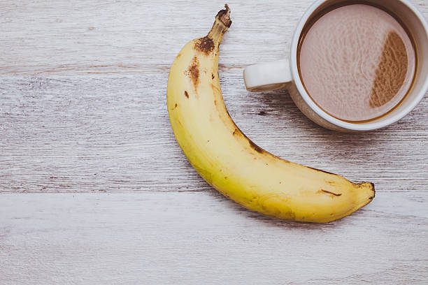 istock Coffee and banana on wooden background 546764318