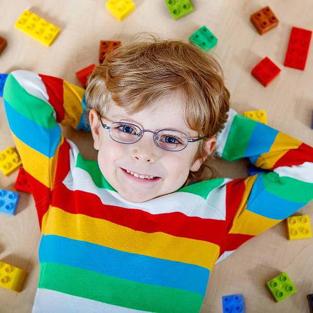istock Little blond child playing with lots of colorful plastic blocks 546765344