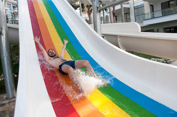 Water park fun Teenage boy having fun sliding in water park sliding down stock pictures, royalty-free photos & images