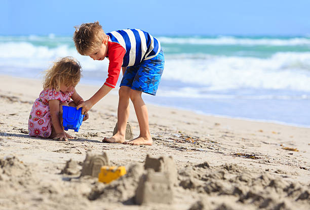 istock kids play with sand on summer beach 546768326