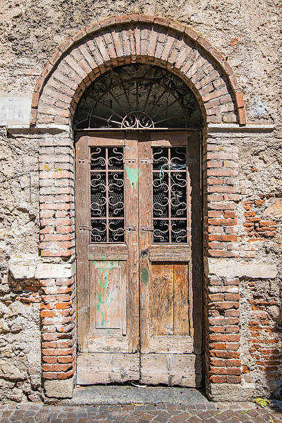 istock Old wooden door with brick archway. 546769490
