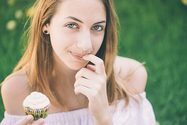 istock Young woman eating cupcake. 546769772