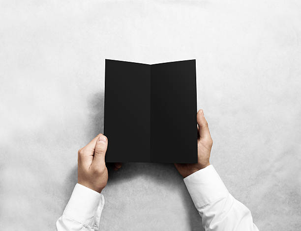 istock Hand opening blank black flyer brochure booklet mockup. Leaflet presentation. 546770872