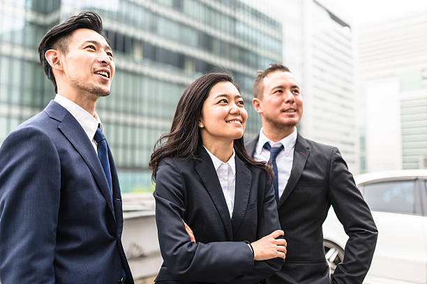 equipo japonés de negocios de pie juntos - professional occupation three people businessman human head fotografías e imágenes de stock