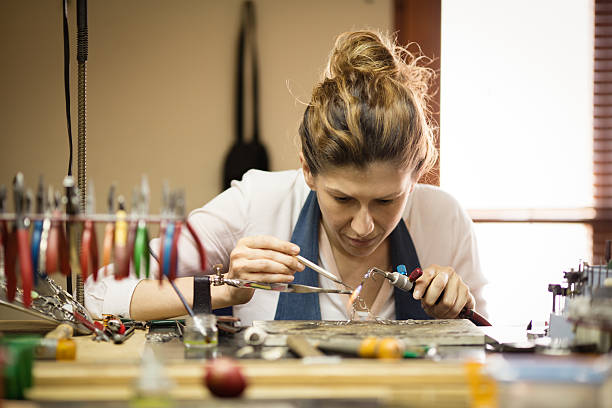 mujer diseñadora hace y diseña joyas en taller - jewelry craftsperson craft jeweller fotografías e imágenes de stock