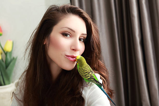 istock woman with green parrot 546775438