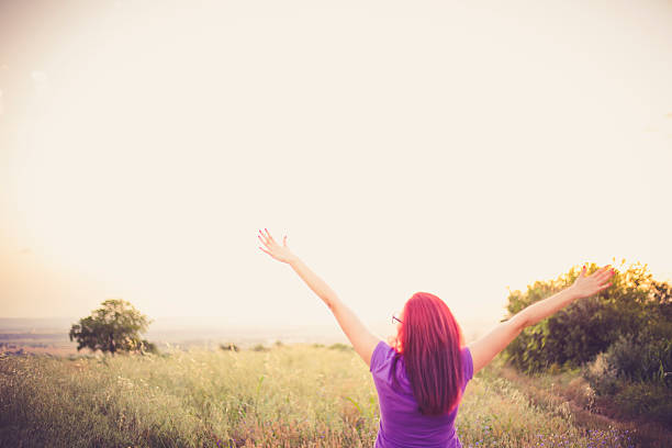 istock Beautiful smiling woman in a field at sunset 546779256