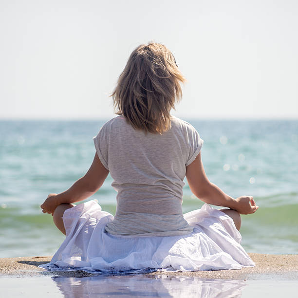 istock Woman meditating at the sea 546781630