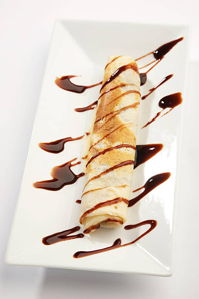 istock Rolled pancakes with chocolate syrup in a plate 546782756