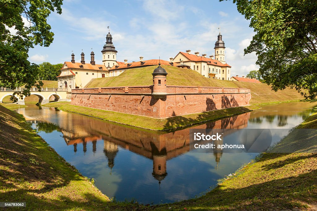 Castle Radziwill Family at Nesvizh, Belarus Nesvizh, Belarus - July 9, 2016: Stone building with towers, battlements and ramparts, surrounded by a moat filled with water. Nesvizh Palace - palace and castle complex. The castle was the ancestral estate of the Radziwill family - the magnates of the Grand Duchy of Lithuania and the Polish-Lithuanian Commonwealth. The castle was built in 1583. The architect is unknown. Located in the northeastern part of the city of Nesvizh in Minsk region of Belarus. Moat Stock Photo