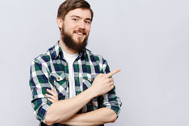 istock Young smiling man is showing something by his hand 546784572