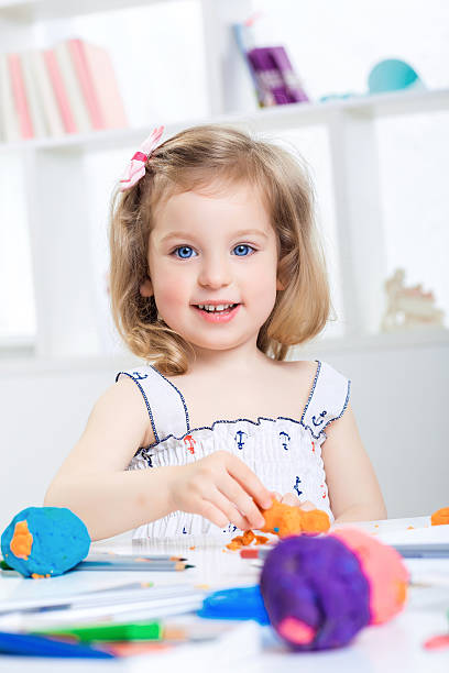 istock girl playing with colored plasticine 546784626