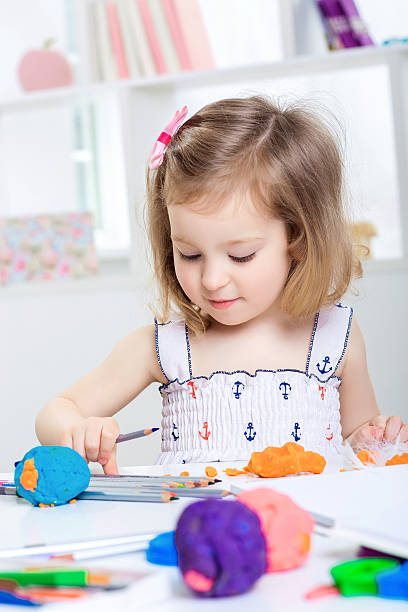 istock girl playing with colored plasticine 546785208