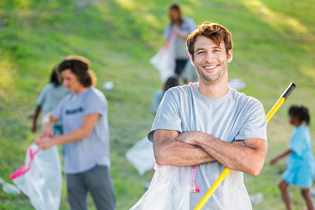 istock Confident man helps neighbors clean up community 546785486