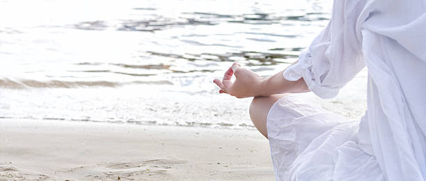 Woman meditating at the sea stock photo