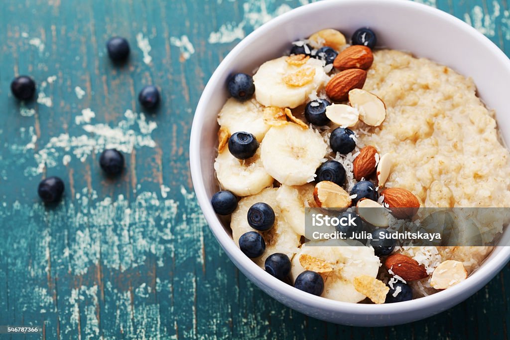 Bol de bouillie d’avoine maison avec banane, myrtilles et amandes - Photo de Porridge libre de droits