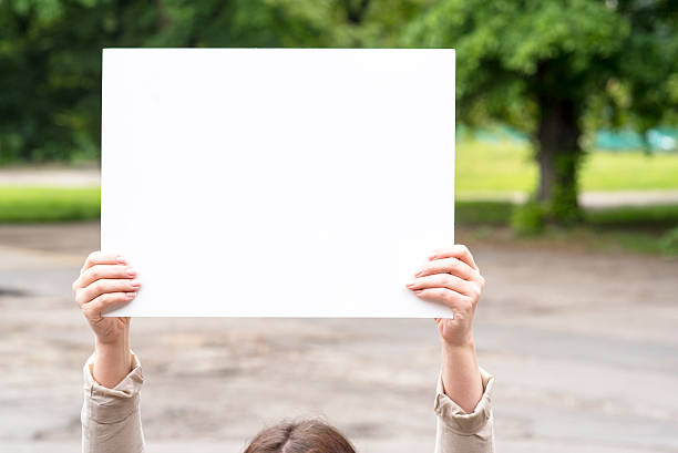 istock woman outside with a blank white card 546787590