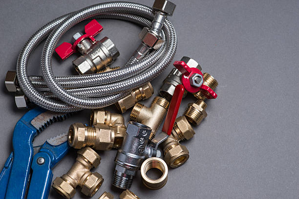 istock Adjustable spanner with assorted plumbing fittings and hose on grey 546787874